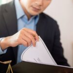Lawyer reviewing AML_CTF customer due diligence documents in a law firm office